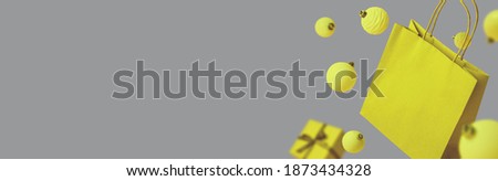 Colors yellow and gray. Color of the year of 2021 illuminating, ultimate grey. Banner with paper bag, Christmas balls and gift. Packaging with empty space for label. Shopping concept with copy space