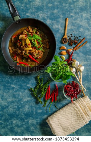 Bolognese sauce - hot juicy ground beef stewed with tomato sauce, spices, basil, finely chopped vegetables and celery in skillet on wooden table, authentic recipe, view from above