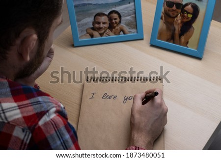 Adult man writing a letter to a woman and looking at photos of the happy traveling couple, a holiday romance.