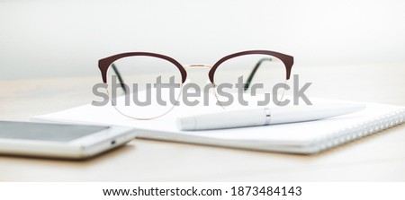 Close-up of glasses with a notebook on the table. Working space