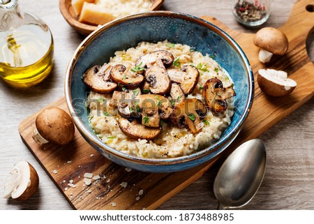 Risotto with brown champignon mushrooms on wooden background.  Royalty-Free Stock Photo #1873488985