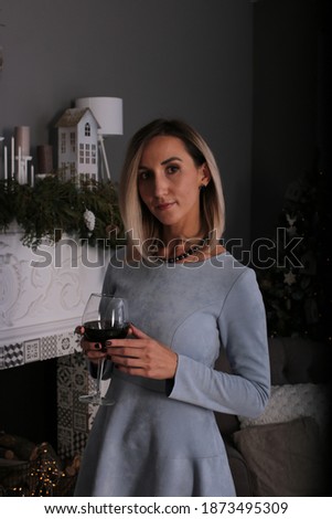 Lovely woman of thirty years old with blond hair in a New Year's interior meets Christmas