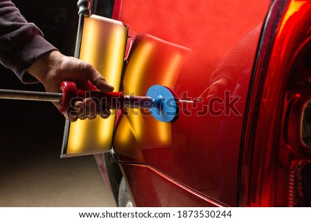 Removing dents on the car. PDR technology. Car body repair without painting. Royalty-Free Stock Photo #1873530244