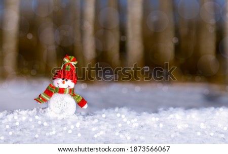 Snowman on the background of the winter forest. Christmas background. Space for greeting or holiday text