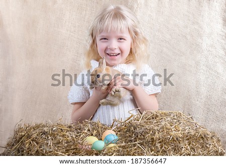 Smiling girl with Easter bunny on a textile background