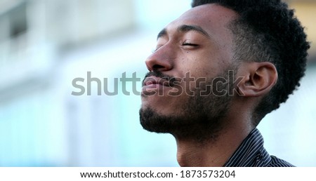 Contemplative young African black man eyes closed in mindful meditation Royalty-Free Stock Photo #1873573204