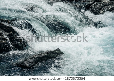Big rapids of powerful mountain river. Beautiful background with azure water in fast river. Frozen motion of tall mountain river rapids. Power majestic nature of highlands. Backdrop of aqua turbulence Royalty-Free Stock Photo #1873573354
