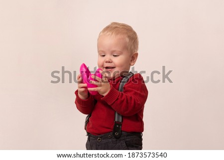 Boy in red jacket open pink heart and laugh
