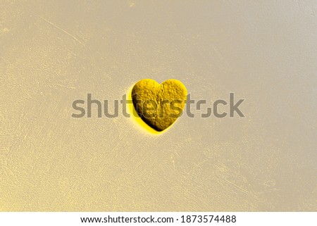 Yellow glowing heart on a gray background. presentation of trendy colors 2021