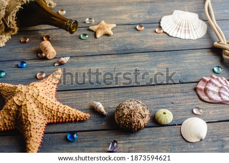 Sea and ocean gifts on a wooden background. Marine things. Sea products. Water Background for real  man captains and sailors. Pirate design. Bottle, rope, star. Underwater treasures.
