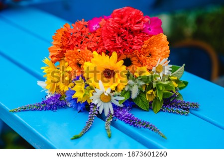 A multi-colored bouquet of wildflowers. Chamomile, cornflowers, calendula, poppy seeds. Flowers are like a rainbow. Bright summer bouquet. Spring flowering.
