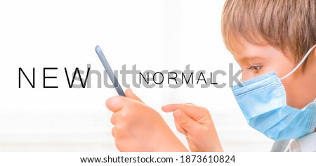 Kid in Medical Mask Using Tablet. Little Boy Wearing Mask Study Online. New Normal Concept. Child Learning Remotely. E learning. Children and Technology. Online Education. Impact Coronavirus. Covid 19