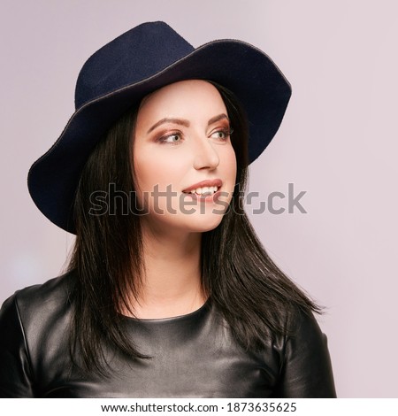 Pretty young woman at black hat. Looking side. High quality photo. Elegant female portrait. Beauty makeup. Grey background. Copyspace. Gorgeous romantic face. Perfume concept.