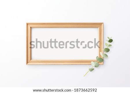 Blank rustic white wood sign on white background with eucalyptus leaf