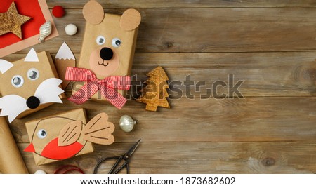 Christmas funny gifts from craft paper on wooden table. Copy space. New year christmas holiday concept
