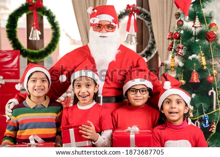 Santa Claus with group of  Children together getting portrait poses  pictures clicked looking at camera