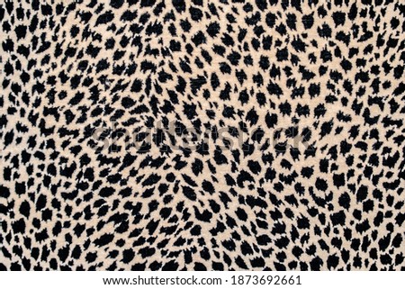 Textured spotted background, repeating seamless pattern of black spots on a beige or yellow background: space for text, leopard skin pattern for fabric