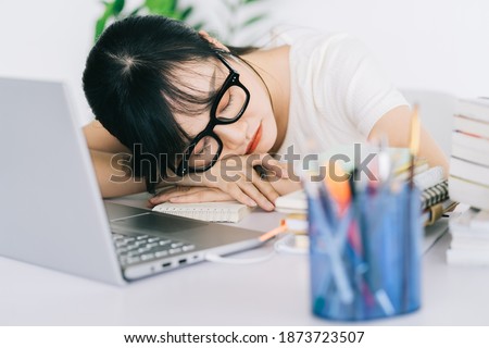 Asian businesswoman is tired and headache with a lot of work on the deadline
