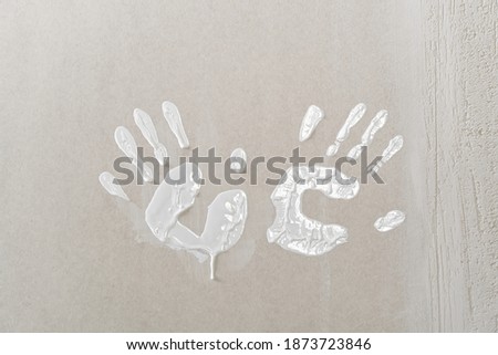 Hand print made with white paint on drywall. painter have fun
