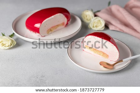 slice of mousse cake on white plate on gray background with white roses. Concept Valentines Day, Mothers Day, Birthday. soft focus