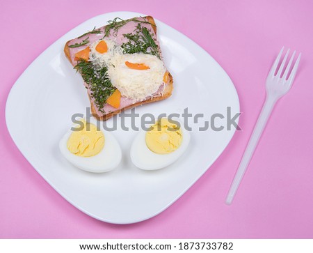Sandwich with edible chicken made of egg on pink background. Food art idea for children. Kid’s breakfast.