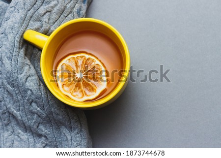 Yellow cup of coffee on gray background with place for text. Bright still life concept with colors 2021. Top view. Copy space.