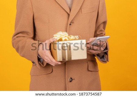 closeup of hands with gift box and mobile phone