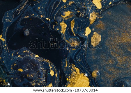 Gold threads of paint, dissolving in the dark blue water, shimmered in the light with sparkles