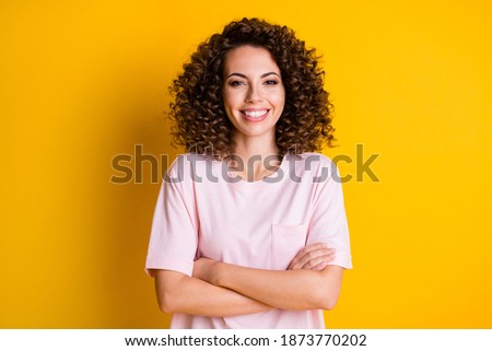Photo of young attractive confident woman happy smile crossed hands isolated over yellow color background