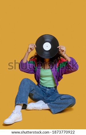 I love music. Sweet dark-haired young girl holding a record