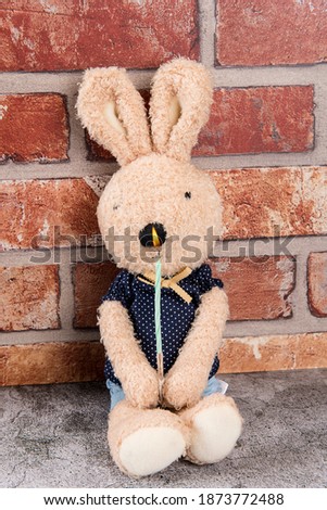 Rabbit doll holding a candle with both hands