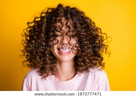Headshot of laughing cheerful girl with curly hairstyle wearing t-shirt white toothy smile isolated on bright yellow color background Royalty-Free Stock Photo #1873777471