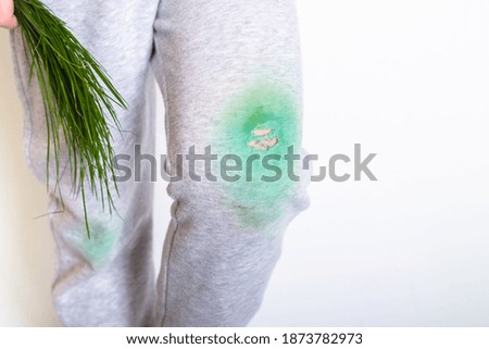dirty stain from the grass on the baby's pants on a white background.place for text