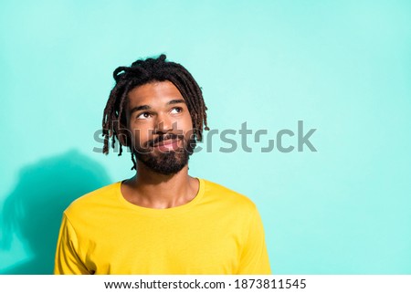 Photo portrait of dreamy black skin man looking at blank space isolated on vivid cyan colored background