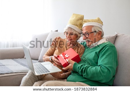 Senior couple on video call for Christmas greetings. Family in Christmas video call. Celebrating new year and christmas during covid-19 pandemic. Friends-Family in Christmas video call.