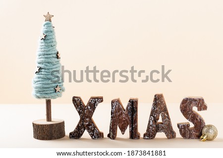 Rustic Christmas background with standing wooden letters spelling Xmas with cristmas tree, copyspace for your greeting card