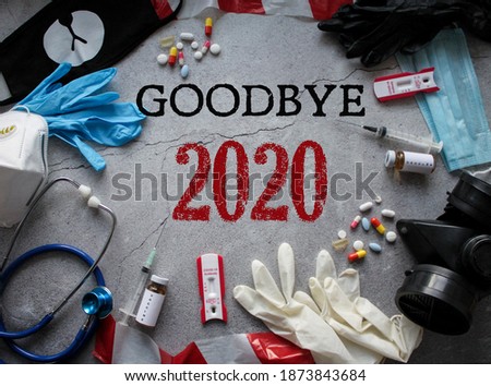 Goodbye 2020! Symbols of the outgoing year: respirators and masks, pills and vaccine, coronavirus tests and tape fencing. The concept of survival and pandemics Royalty-Free Stock Photo #1873843684