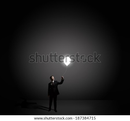 businessman holding flying light bulb