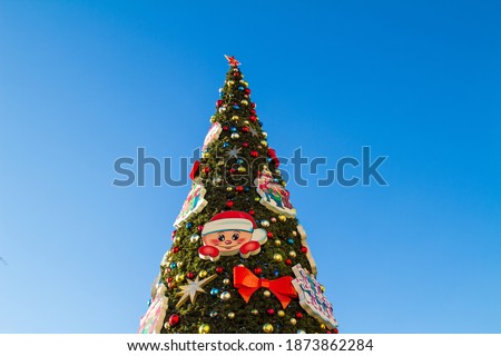 Artificial Christmas tree on a blue sky background on a Sunny day. Horizontal orientation