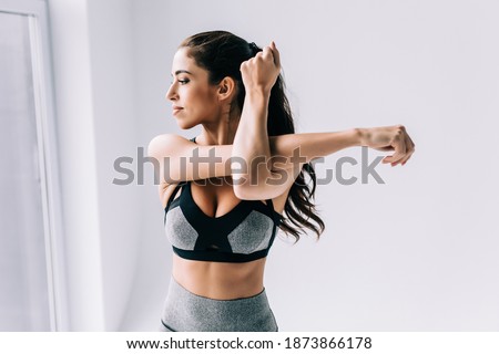 Picture showing young woman stretching at home in the morning