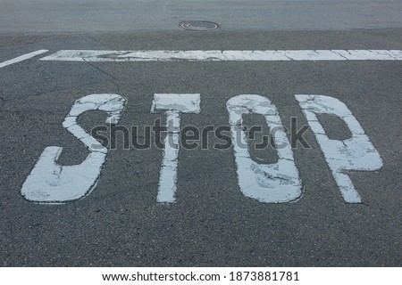 STOP sign and stop line are marked on the asphalt of the roadway. Stock photo