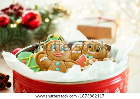 Christmas cookies with festive decoration in a round red tin box. Christmas present with cookies decorated
