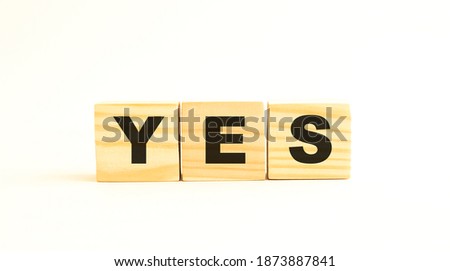 The word YES. Wooden cubes with letters isolated on white background.