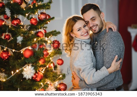 Picture showing young couple hugging over Christmas tree