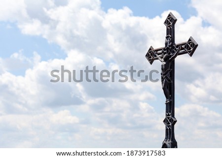 Metal christian cross on blue cloudy sky background, copy space. Catholic church symbol, Jesus Christ Faith, spirituality, chrisitanity and catholicism Religious symbols abstract, crucifix, text space