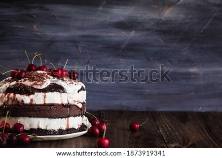 Delicious Black Forest Cherry Cake, Schwarzwald pie dessert, over a dark rustic wood table. Selective focus with blurred background and free space for text. 