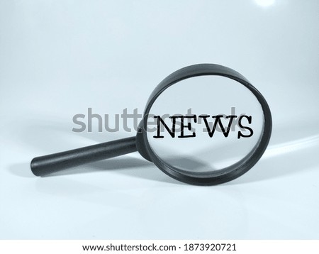 Selective focus.NEWS in black word with magnifying glass isolated on white background.Education and business concept.