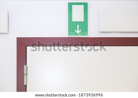 Exit emergency sign on top of a door with white walls