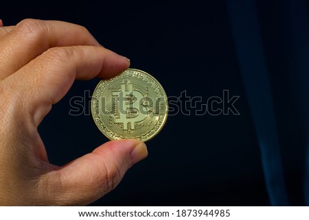 gold bitcoin in the man's hand