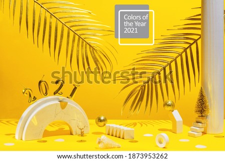 Golden candles with the new year 2021 on the marble arch, palm leaves, column, stairs, balls, Christmas trees, confetti on a yellow background with the horizon. Festive trend still life.